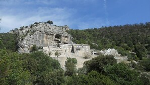 A historic stone building with a rugged cliffside location, surrounded by dense greenery. - Holiday Home in Sumartin with Seaview, Air condition, WIFI, Washing machine (682-2) (Sumartin)