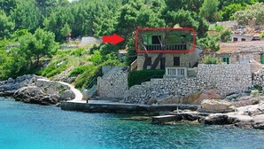 A coastal property with a stone wall, a balcony, and a view of the sea. - Apartment in Karbuni with Seaview, Terrace, Air condition, WIFI (217-3) (Karbuni)