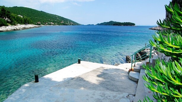 A concrete staircase leading to a clear blue sea with a rocky shoreline and greenery in the background. - Apartment in Karbuni with Seaview, Terrace, Air condition, WIFI (217-3) (Karbuni)
