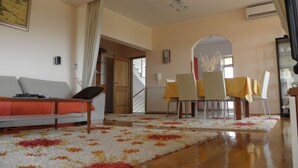A living room with a sofa, a dining table with chairs, and a patterned rug. - Apartment in Premantura with Seaview, Terrace, Air condition, WIFI (3352-29) (Premantura)