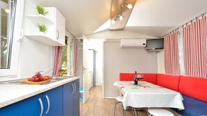 A compact kitchen with a sink, a countertop with vegetables, and a window with curtains. - Holiday Home in Drage with Seaview, Balcony, Air condition, WIFI (571-1) (Drage)
