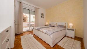 A bedroom with a bed, bedside tables, a window with curtains, and a view of the outside. - Apartment in Palit with Terrace, Air condition, WIFI, Dishwasher (820-2) (Palit)