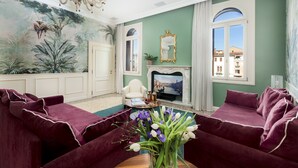 A living room with a fireplace, a sofa set, a chandelier, and a mural on the wall. - Ca' Mainella Grand Canal (Venice)