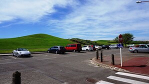 Un parking où sont garées différentes voitures, avec un passage piéton à proximité.