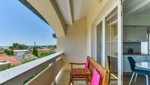 Un balcone con una panchina in legno e vista sulla città.