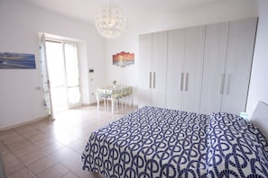 Une chambre comprenant un lit, une armoire et un coin repas avec une table et des chaises.