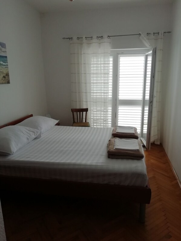 A bedroom with a bed, a chair, and a view through a window. - Apartment in Pisak with Seaview, Balcony, Air condition, WIFI (195-1) (Pisak)