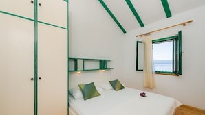 Une chambre à coucher avec un lit, une fenêtre avec des rideaux et une vue sur la mer.