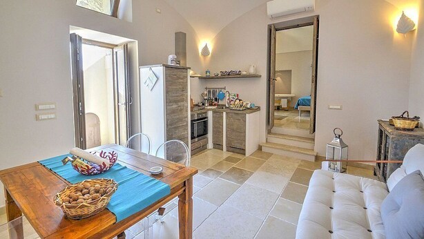 Un espacio habitable compacto con comedor, kitchenette y sofá.
