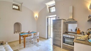 Una cocina moderna con una isla central, horno integrado y un ventanal grande.