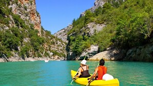 A couple kayaking on a turquoise sea with rocky cliffs and greenery. - Apartment in Stanići with Seaview, Terrace, Air condition, WIFI (3782-4) (Stanici)