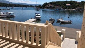 A marina with boats docked, a clear sky, and a view of houses in the background. - Apartment in Lumbarda with Seaview, Terrace, Air condition, WIFI (128-1) (Lumbarda)