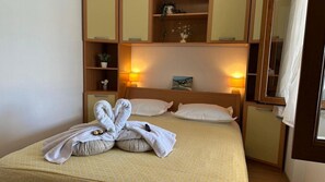A hotel room with a bed, bedside lamps, a mirror, and a shelf with decorative items. - Apartment in Lumbarda with Seaview, Terrace, Air condition, WIFI (128-1) (Lumbarda)