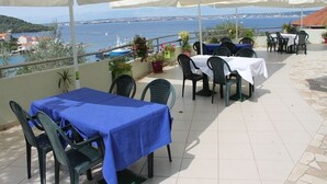 An outdoor patio with tables and chairs, a view of the sea, and potted plants. - Apartment in Kali with Seaview, Balcony, Air condition, WIFI (4566-5) (Kali)