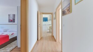 A narrow hallway with wooden flooring leading to a bedroom with a bed and a red blanket. - Apartment in Vir with Terrace, Air condition, WIFI, Dishwasher (4589-1) (Vir)