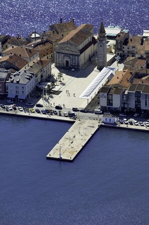 An aerial view of a coastal town with a prominent church, a tall tower, and a pier extending into the water. - Apartment in Savudrija with Terrace, Air condition, WIFI, Dishwasher (4264-1) (Savudrija)