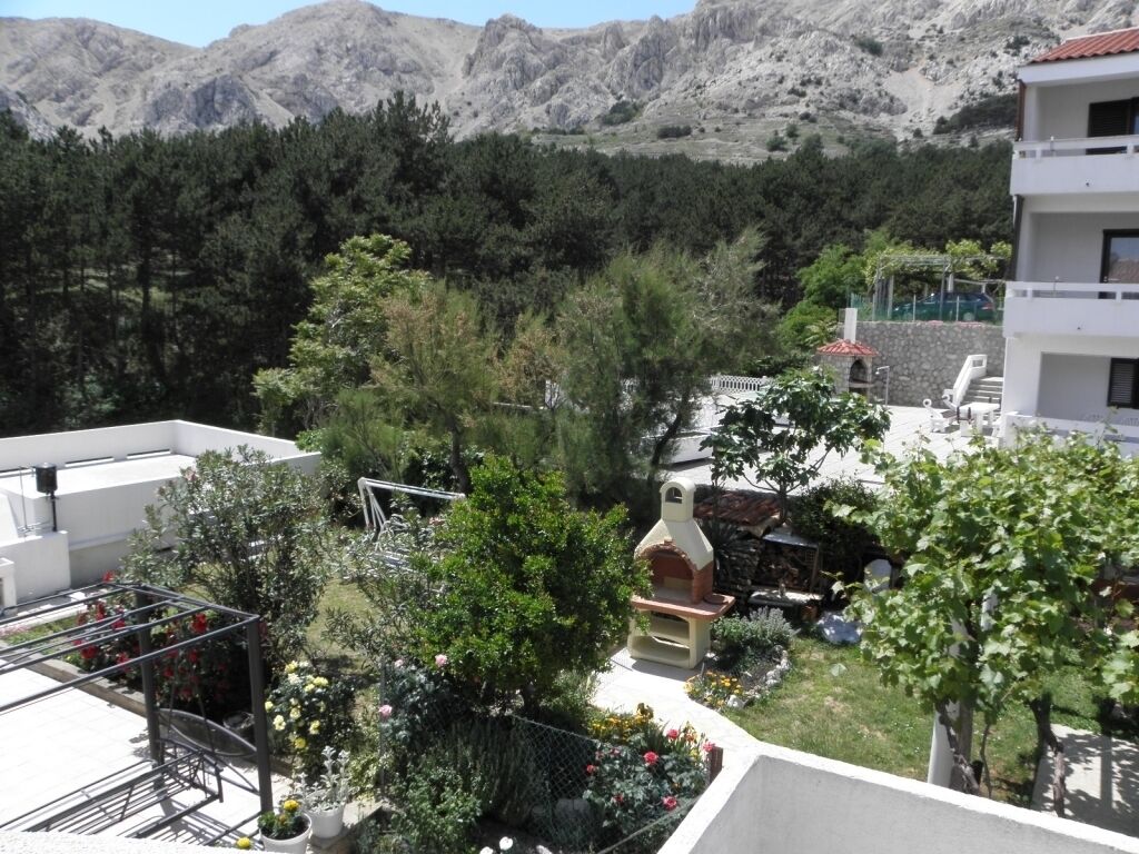 Un quartier résidentiel doté d’un barbecue, de plantes en pot et offrant une vue sur les montagnes.