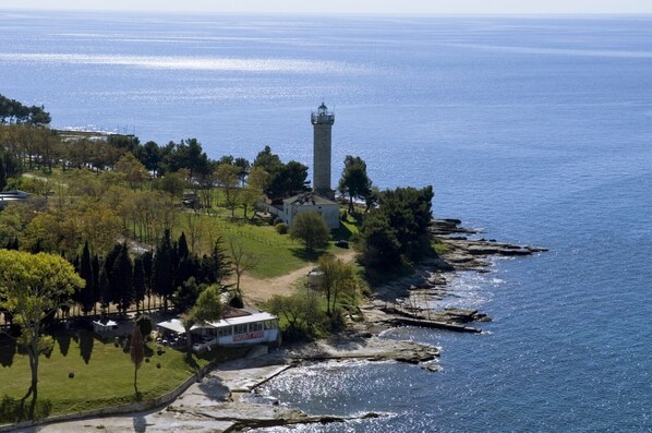A coastal property with a lighthouse, a grassy area, and a building labeled "FAVORIT PIVO".