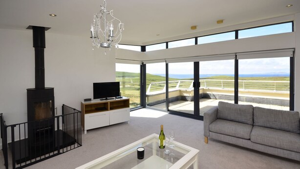 A modern living room with a fireplace, a sofa, a coffee table, and a television. - Property 260 - Moyard - sleeps 8 guests  in 4 bedrooms (Connemara)