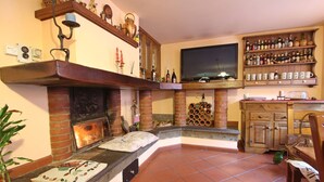 Uma sala de estar aconchegante com lareira, televisão e adega.