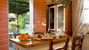 A wooden dining table with chairs, a pitcher, and plates of food.