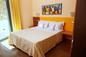 A hotel room with a bed, a painting on the wall, and a window with curtains. - Villa Carminia Grande: A splendid and luminous three-story villa located on the coast in front of the island of Capri, with Free WI-FI. (Massa Lubrense)