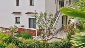 A white building with multiple windows and a staircase leading to a covered entrance. - Studio apartment in Mošćenička Draga with Seaview, Terrace, Air condition, WIFI (4364-2) (Mošcenicka Draga)