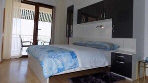 A bedroom with a bed, a desk, and a chair. There is a balcony with a view. - Studio apartment in Mošćenička Draga with Seaview, Terrace, Air condition, WIFI (4364-2) (Mošcenicka Draga)