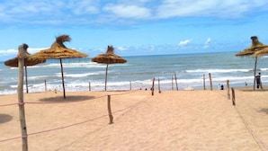 A beach volleyball court with thatched umbrellas and a net. - Very nice apartment in Savannah Beach 4210 (Sidi Rahal)