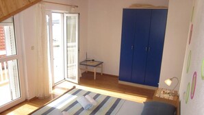 Ein Schlafzimmer mit Bett, Schreibtisch und Kleiderschrank.