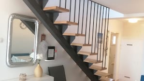 A staircase with wooden steps and black railings, a white cabinet with a mirror, a vase with flowers, and a black chair. - Holiday Home in Miholaščica with Terrace, Air condition, WIFI (66-1) (Miholašcica)