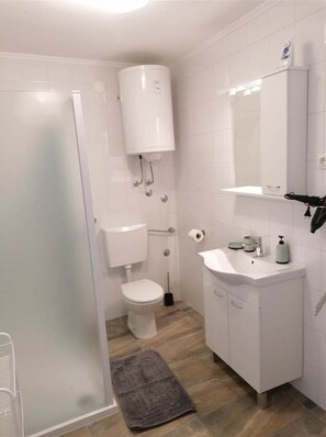 Une salle de bain moderne avec des toilettes, un lavabo et un miroir.