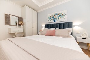 A bedroom with a bed, bedside tables, a wardrobe, a mirror, and a painting on the wall. - Apartment in Trogir with Seaview, Terrace, Air condition, WIFI (3459-3) (Trogir)