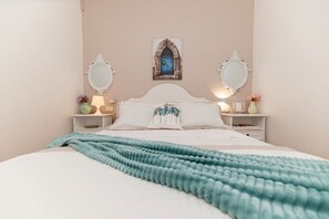 A bedroom with a bed, two nightstands, a mirror, a wall-mounted picture, and a teal throw blanket. - Apartment in Trogir with Seaview, Terrace, Air condition, WIFI (3459-3) (Trogir)