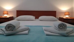 A hotel room with a bed, two nightstands, and two lamps.