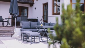 An outdoor seating area with a table, chairs, and a sofa. - Landhaus Lodges Kaprun - Josef, pool, skiing - walking dist (Kaprun)