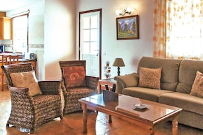 A living room with wicker chairs, a sofa, a coffee table, and a painting on the wall. - Casa Mar in Tijarafe (Tijarafe)