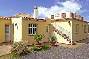 A two-story building with a tiled roof, a chimney, and a staircase leading to the upper floor. - Casa Mar in Tijarafe (Tijarafe)