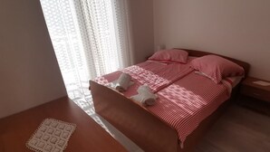 A bedroom with a bed, a nightstand, and a small table. - Apartment in Žuljana with Seaview, Terrace, WIFI, Dishwasher (3558-2) (Žuljana)