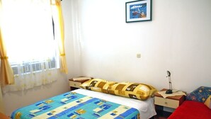 A bedroom with a bed, a nightstand, a lamp, a window with curtains, and a framed picture on the wall. - Apartment in Medulin with Balcony, Air condition, WIFI, Washing machine (3488-2) (Medulin)