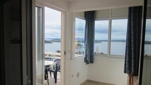 Ein Balkon mit Blick auf ein Gewässer und eine entfernte Insel.