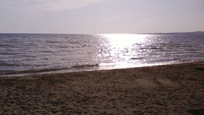 A beach with a sandy shore and calm water reflecting sunlight. - Apartment in Privlaka with Seaview, Balcony, Air condition, WIFI (667-2) (Privlaka)