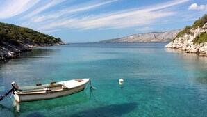 A boat anchored in clear turquoise water with rocky cliffs on both sides. - Apartment in Basina with Seaview, Terrace (3450-3) (Stari Grad)
