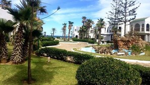 Un resort con palmeras, una piscina y edificios blancos con arcos.