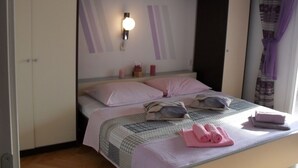 A bedroom with a bed, pillows, a wall-mounted light, and a window with curtains. - Apartment in Lopar with Terrace, Air condition, WIFI, Washing machine (87-2) (Lopar)
