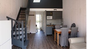 Una cucina moderna con forno a microonde, un tavolo da pranzo con sedie e una scala che conduce a un piano superiore.
