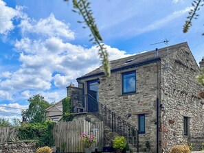 A stone house with a wooden fence, a balcony, and potted plants. - The Owlery at Aysgarth (Aysgarth, near Leyburn)
