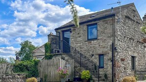 A stone house with a wooden fence, a balcony, and potted plants. - The Owlery at Aysgarth (Aysgarth, near Leyburn)