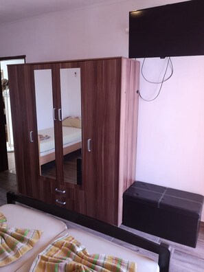 Ein Schlafzimmer mit großem Kleiderschrank, einem Bett und einer Bank.