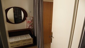 A room with a wooden wardrobe, a mirror, a small sofa with storage drawers, and a curtain. - Studio apartment in Baška with Terrace, Air condition, WIFI, Washing machine (863-1) (Baška)